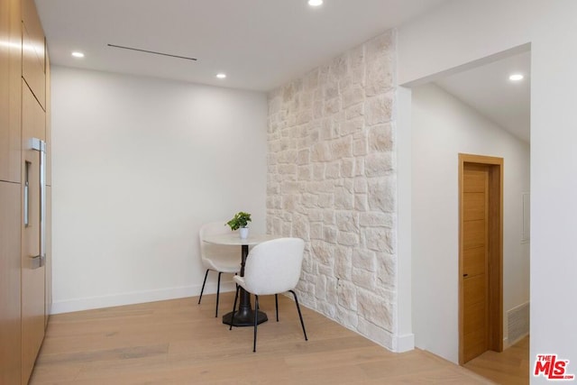 hallway featuring light hardwood / wood-style flooring and lofted ceiling