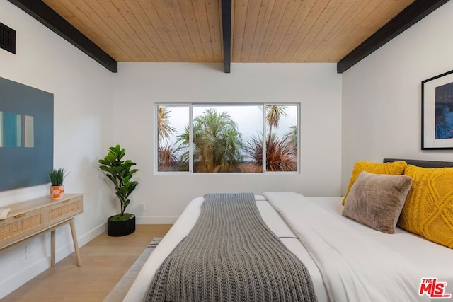 bedroom featuring beamed ceiling, light wood-type flooring, and wooden ceiling