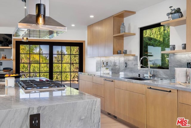 kitchen featuring sink, light brown cabinets, light stone counters, decorative backsplash, and island range hood