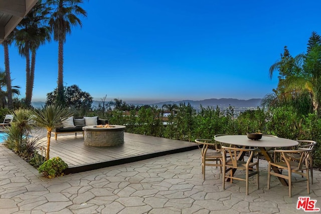 view of patio / terrace with a deck with mountain view and an outdoor fire pit