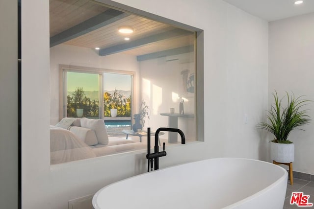 bathroom with tile patterned flooring, a washtub, beam ceiling, and wood ceiling