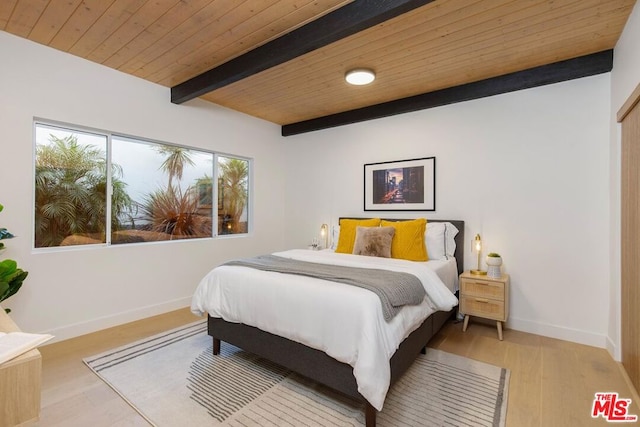 bedroom with beam ceiling, light wood-type flooring, and wooden ceiling