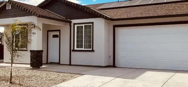 doorway to property with solar panels and a garage