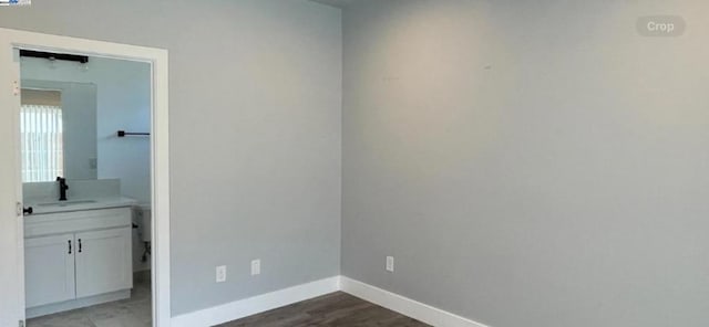 spare room featuring sink and dark wood-type flooring