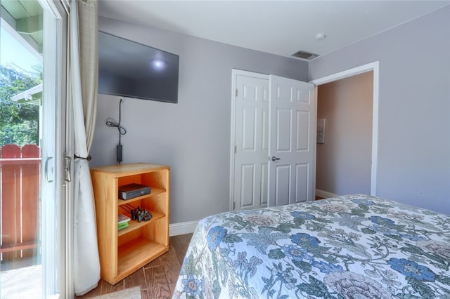 bedroom with hardwood / wood-style floors and multiple windows