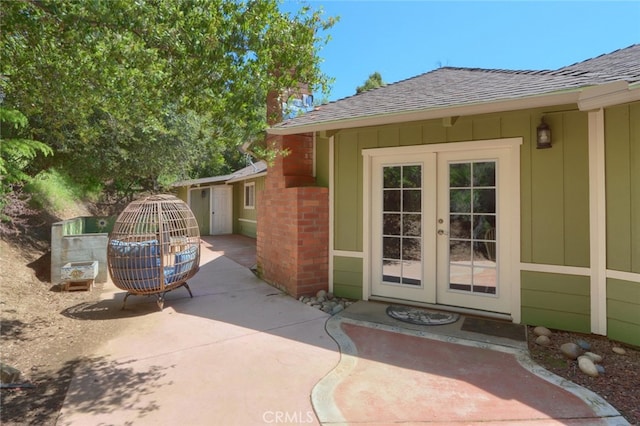 view of exterior entry with french doors and a patio area