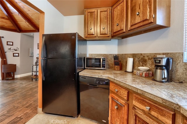 kitchen featuring tasteful backsplash, black appliances, light hardwood / wood-style flooring, wooden ceiling, and vaulted ceiling with beams