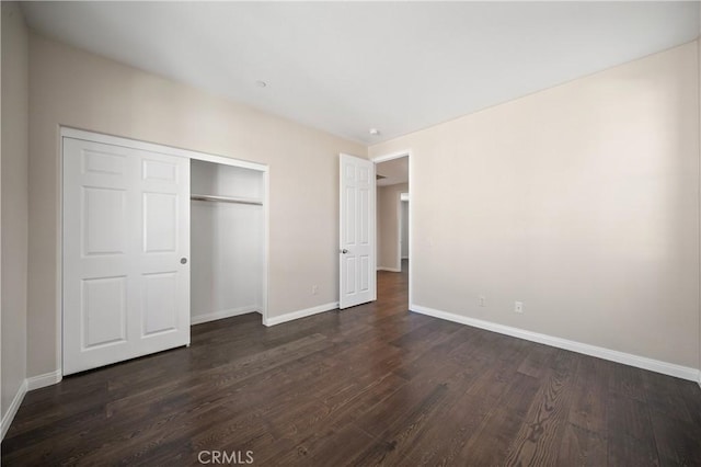 unfurnished bedroom with dark hardwood / wood-style flooring and a closet