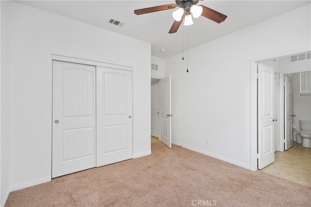 unfurnished bedroom with connected bathroom, ceiling fan, a closet, and light colored carpet