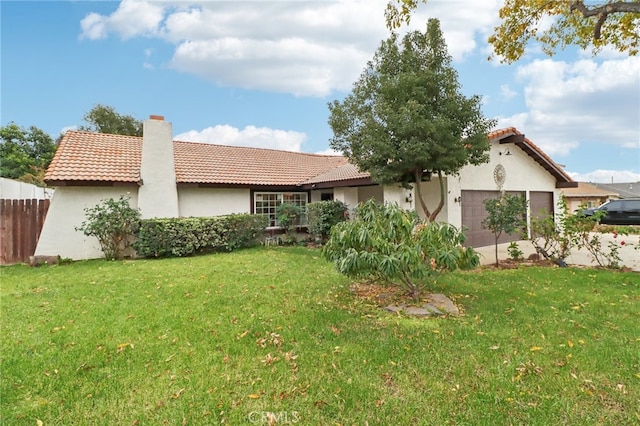 back of property with a lawn and a garage