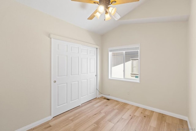 unfurnished bedroom featuring a closet, light hardwood / wood-style floors, vaulted ceiling, and ceiling fan