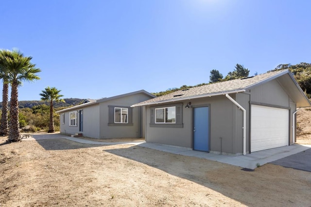 ranch-style home featuring a garage and an outdoor structure