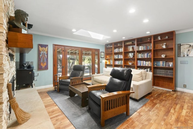 interior space featuring a skylight, crown molding, and light hardwood / wood-style floors