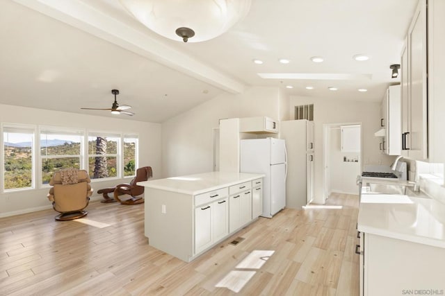 kitchen with sink, vaulted ceiling with beams, white fridge, white cabinets, and light wood-type flooring