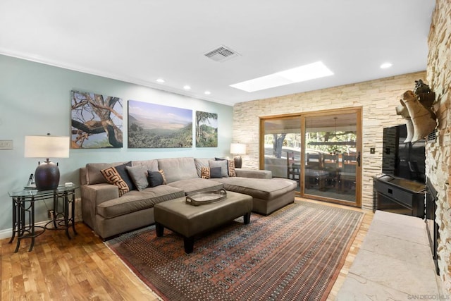 living room with a skylight and wood-type flooring