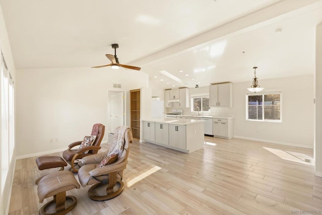 interior space featuring vaulted ceiling with beams, ceiling fan, light wood-type flooring, and sink