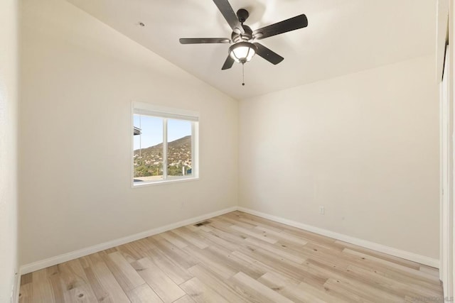 empty room with ceiling fan, light hardwood / wood-style floors, and lofted ceiling