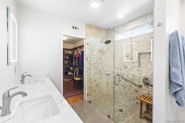 bathroom featuring sink, an enclosed shower, and hardwood / wood-style flooring