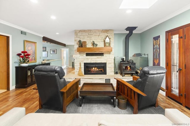 living room with hardwood / wood-style flooring, a skylight, and ornamental molding