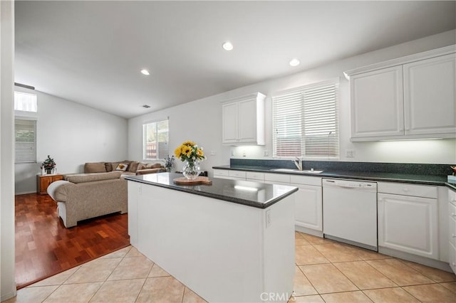 kitchen with white cabinetry, dishwasher, light tile patterned flooring, and sink