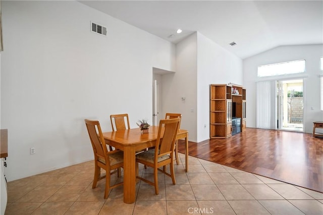 dining room featuring light hardwood / wood-style floors and vaulted ceiling