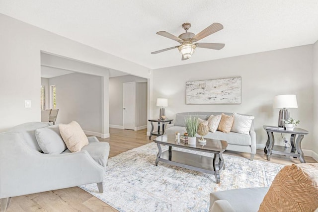 living room featuring light hardwood / wood-style flooring and ceiling fan