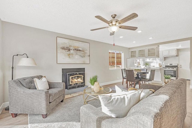 living room with ceiling fan and light wood-type flooring