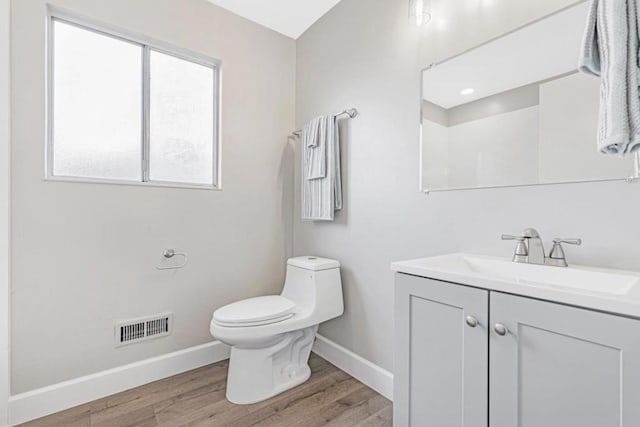 bathroom featuring vanity, hardwood / wood-style flooring, and toilet