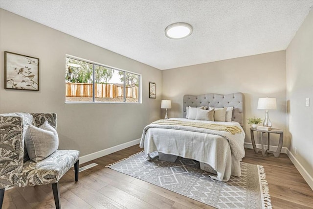 bedroom with hardwood / wood-style flooring and a textured ceiling