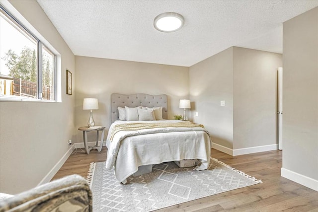 bedroom featuring wood-type flooring and a textured ceiling