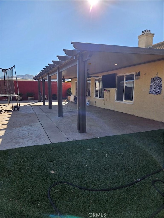 view of patio / terrace with a trampoline and a pergola