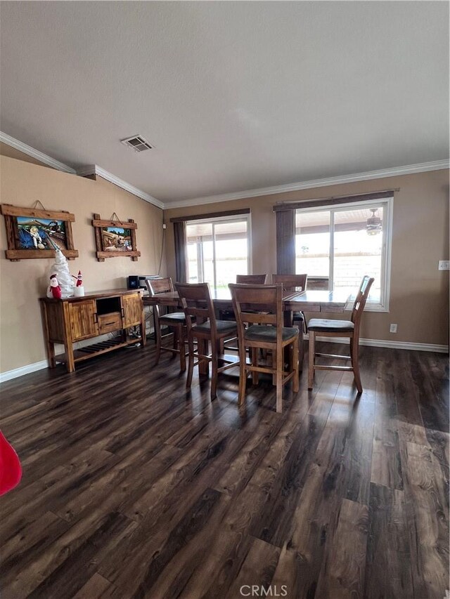 dining space featuring dark wood-type flooring and crown molding