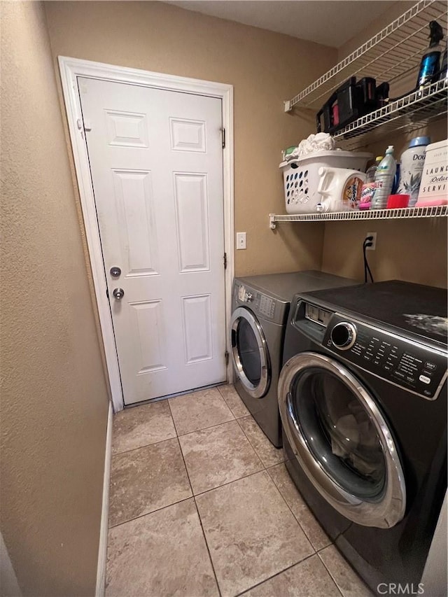 laundry area with separate washer and dryer and light tile patterned flooring