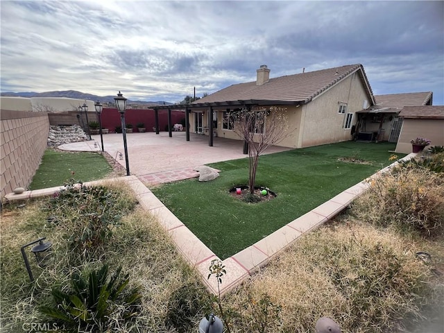 view of yard featuring a patio area, central AC, and a mountain view