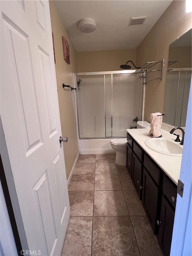 full bathroom with toilet, tile patterned flooring, vanity, and shower / bath combination with glass door