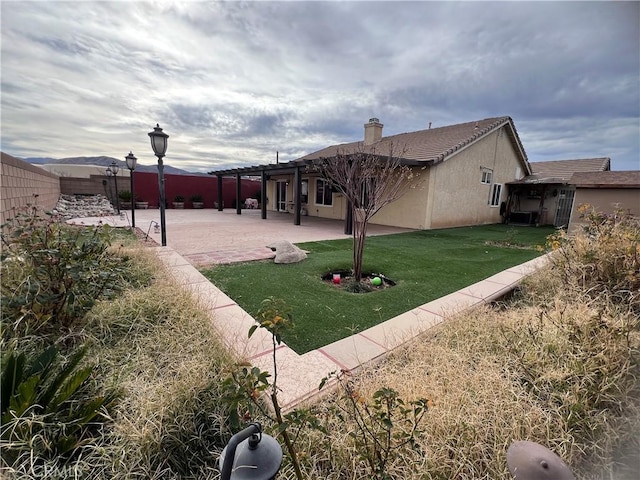 back of house with a pergola, a patio area, and a yard