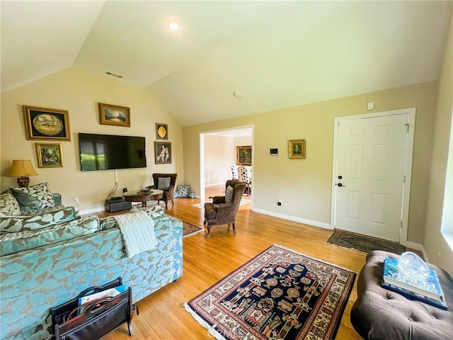 living room with light hardwood / wood-style flooring and vaulted ceiling