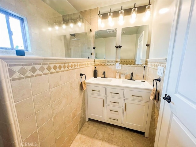 bathroom featuring tile patterned floors, vanity, tile walls, and walk in shower