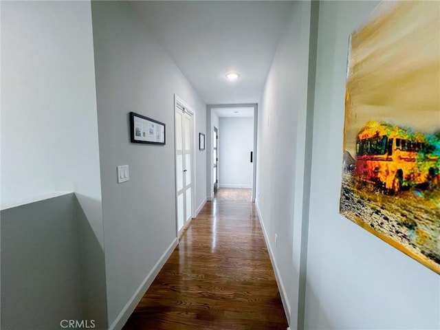 corridor with dark hardwood / wood-style flooring