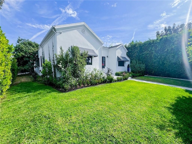 view of side of home with a yard