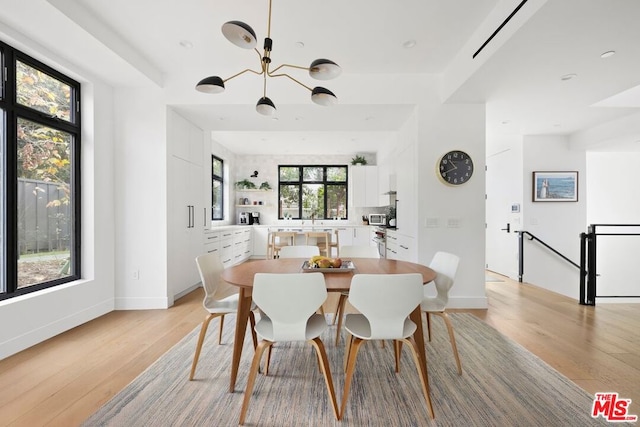 dining area featuring a chandelier, a wealth of natural light, and light hardwood / wood-style flooring