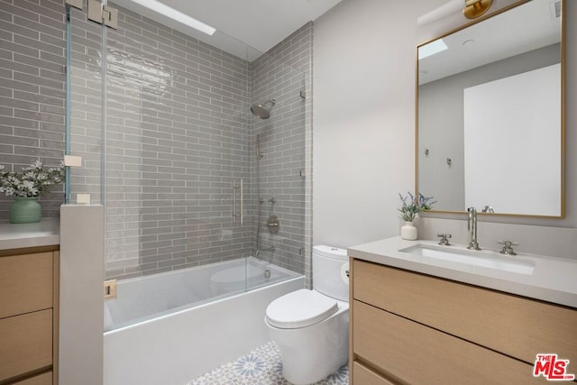 full bathroom with vanity, tiled shower / bath combo, and toilet