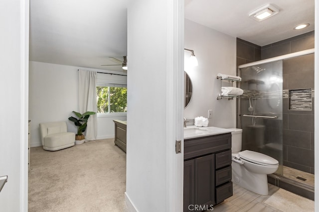 bathroom with ceiling fan, vanity, an enclosed shower, and toilet