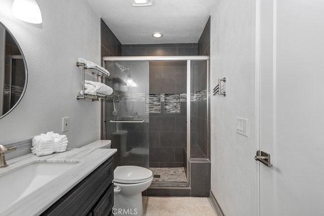 bathroom with tile patterned flooring, vanity, toilet, and walk in shower