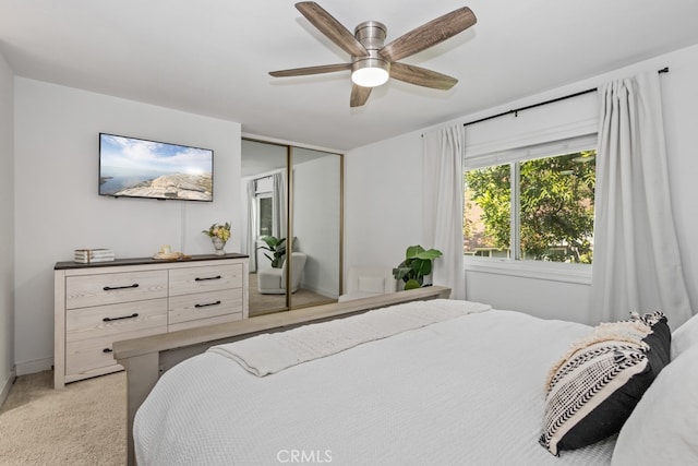 bedroom with light colored carpet, a closet, and ceiling fan