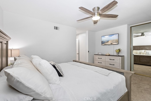 carpeted bedroom featuring ceiling fan and ensuite bath