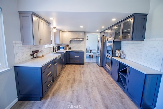 kitchen featuring backsplash, sink, stainless steel fridge, black electric cooktop, and light hardwood / wood-style floors