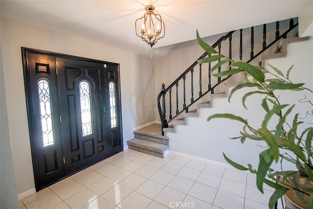 tiled entryway featuring a notable chandelier