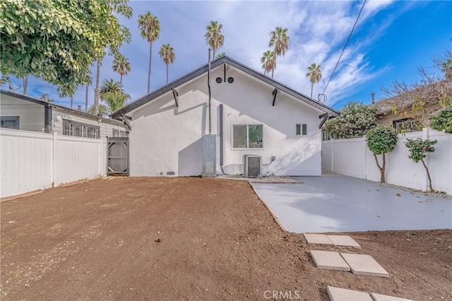 rear view of property with central AC unit and a patio area