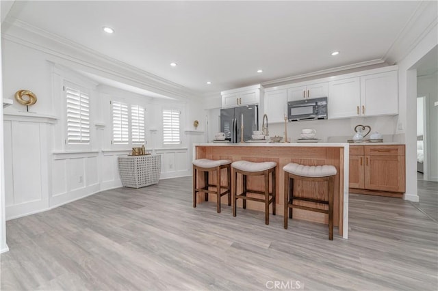 kitchen featuring stainless steel refrigerator with ice dispenser, white cabinetry, and a center island